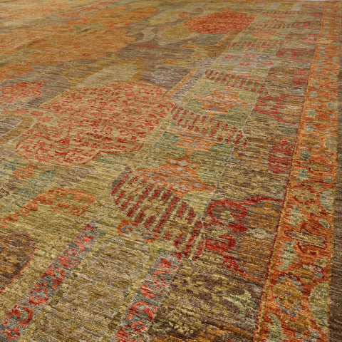 A close-up view of an area rug with a distressed, vintage-style design in muted tones of rust red, terracotta, soft brown, and soft green.