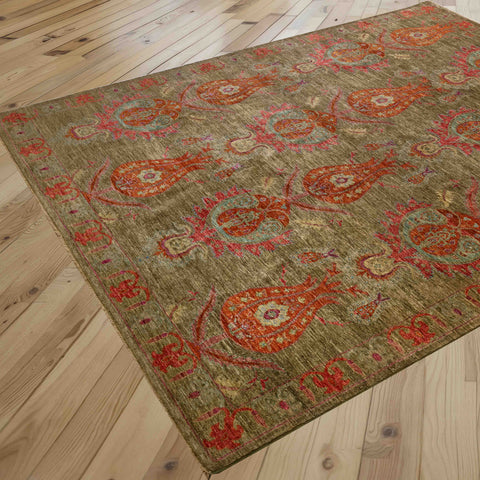 A rectangular area rug with an unusual pattern, shown laid out on a light-colored wooden plank floor. The rug features a muted olive-green base with prominent burnt orange and crushed raspberry tulips.