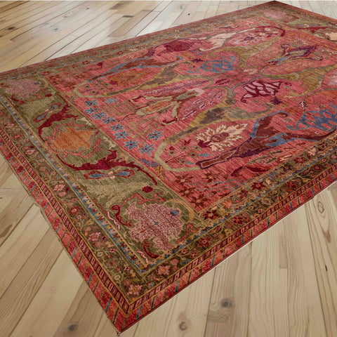 A traditional oriental-style area rug with an intricate floral and abstract pattern sits on a light-coloured wooden floor.