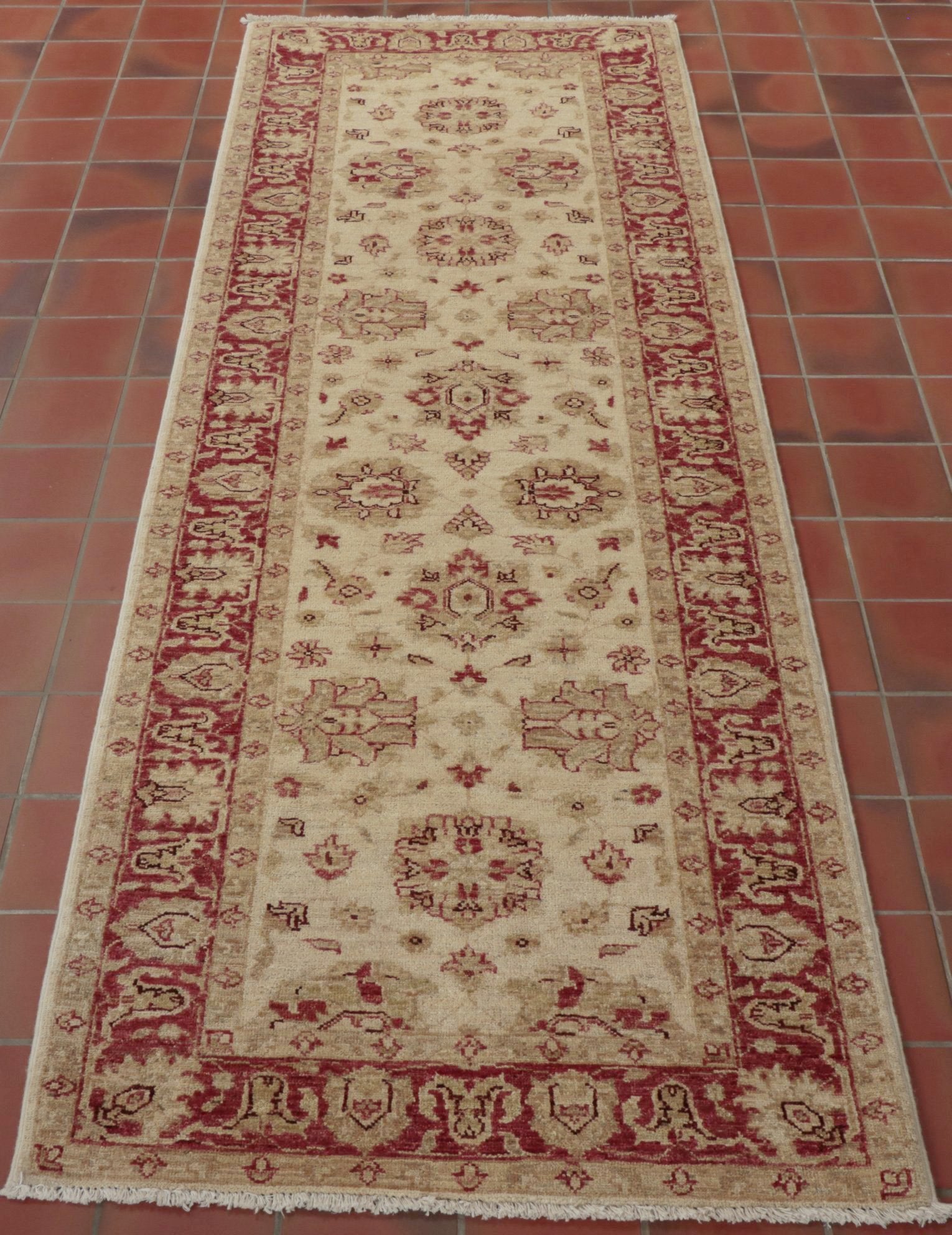 This runner will bring light and warmth to any hallway or landing.  A pinky red is used in the border and in some of the floral decoration. There is a high level of decoration in the main ground. 