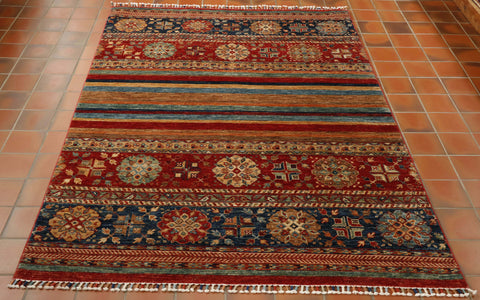 This is a hand made Samarkand rug from northwest Afghanistan. It is made from hand-spun vegetable dyed wool from the Karakul sheep that wander the mountainous terrain. The weavers have mixed up the design to incorporate both traditional and modern influences. The colours used are rich red, tan, cream, terracotta, gold, sea green and two shades of blue.