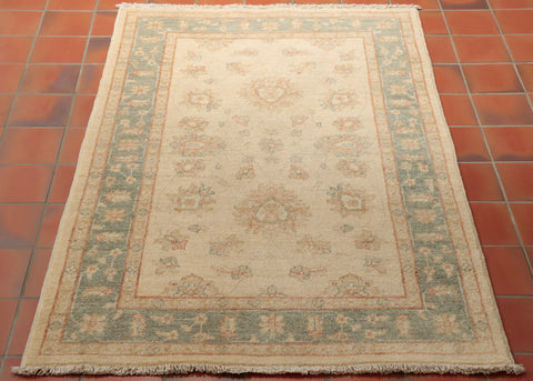 This is a hand knotted Afghan Ziegler in very pale gentle colours. Made from Hand spun Karakul wool, the background is a warm cream colour and the border a soft blue/green shade. There are traces of a soft terracotta used as highlights in the subtle floral design. This is the sort of rug that you could put in your room and it would look as if it had always been there.